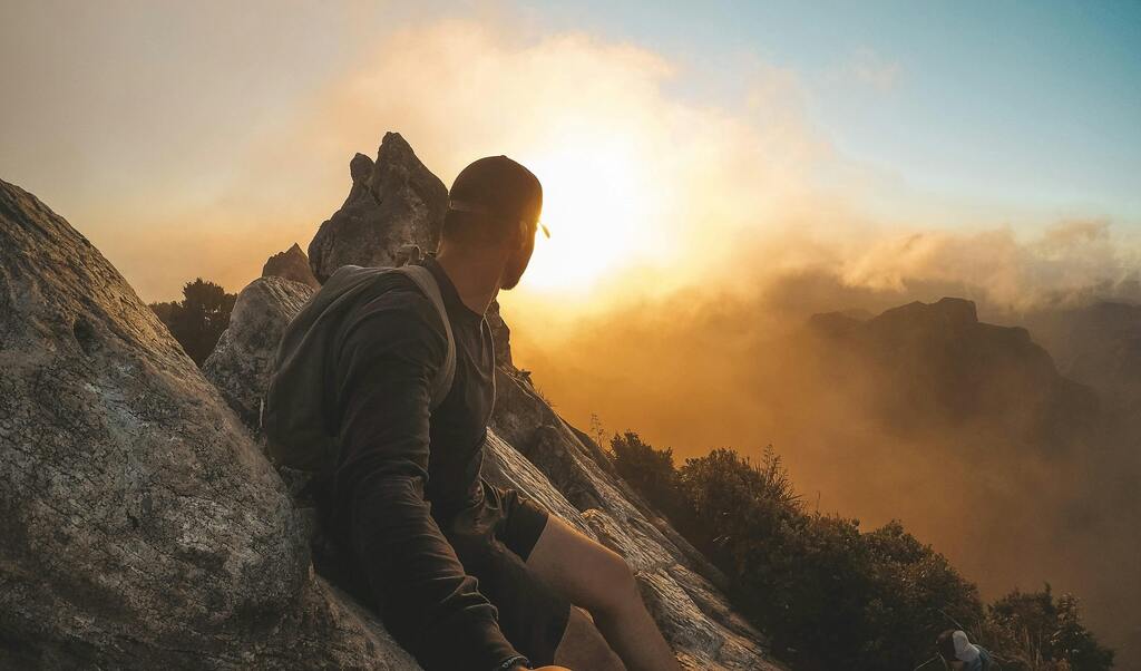 homme en haut d'un sommet de montagne symbolisant la qualité et l'excellence